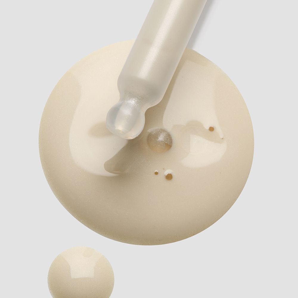 Pipette mit weißer Flüssigkeit. Tropfen auf Oberfläche.