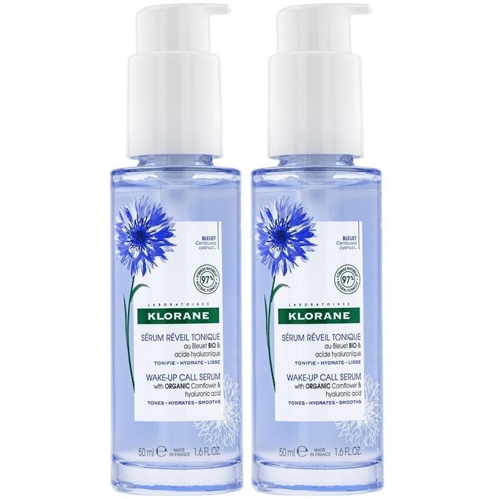 Zwei blaue Flaschen mit weißem Pumpkopf. Aufschrift: KLORANE Sérum Réveil Tonique. Mit Kornblume und Hyaluronsäure.