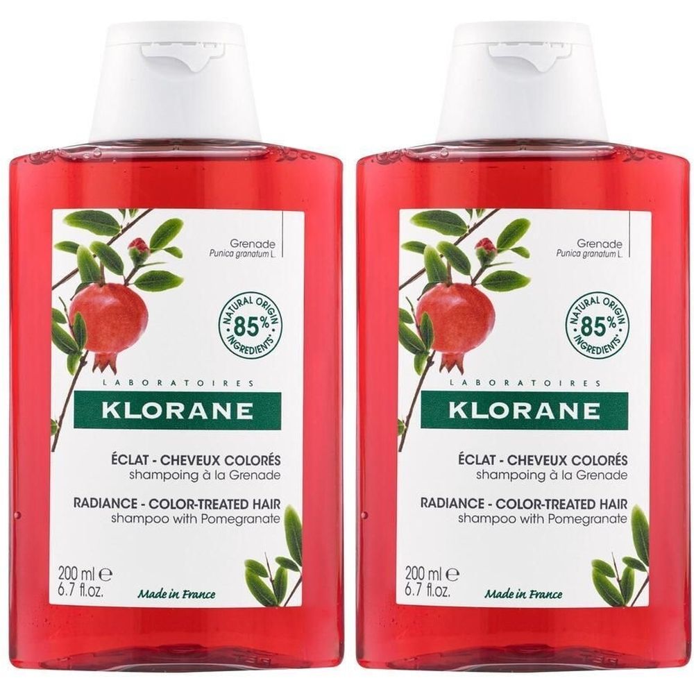 Deux flacons de shampoing KLORANE à la grenade. Liquide rouge, bouchon blanc. Inscription: ÉCLAT - CHEVEUX COLORÉS, RADIANCE - COLOR-TREATED HAIR.