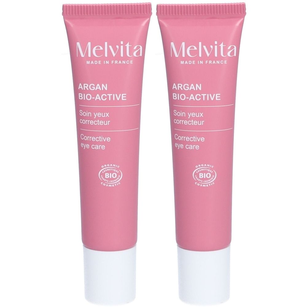 Deux tubes de soin pour les yeux Melvita Argan Bio-Active. Tubes roses avec bouchon blanc. Texte: Argan Bio-Active, Soin yeux correcteur.