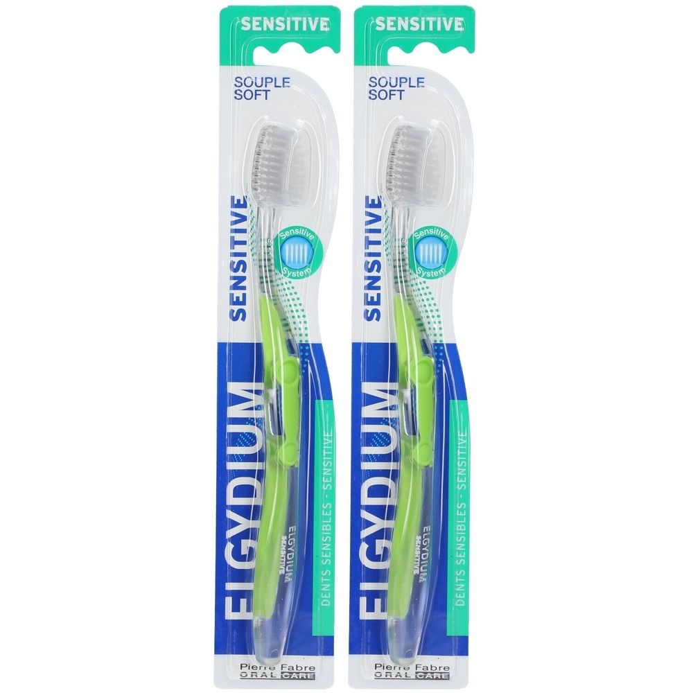 Deux brosses à dents sous blister. Manches verts, têtes transparentes. Inscription: ELGYDIUM Sensitive.