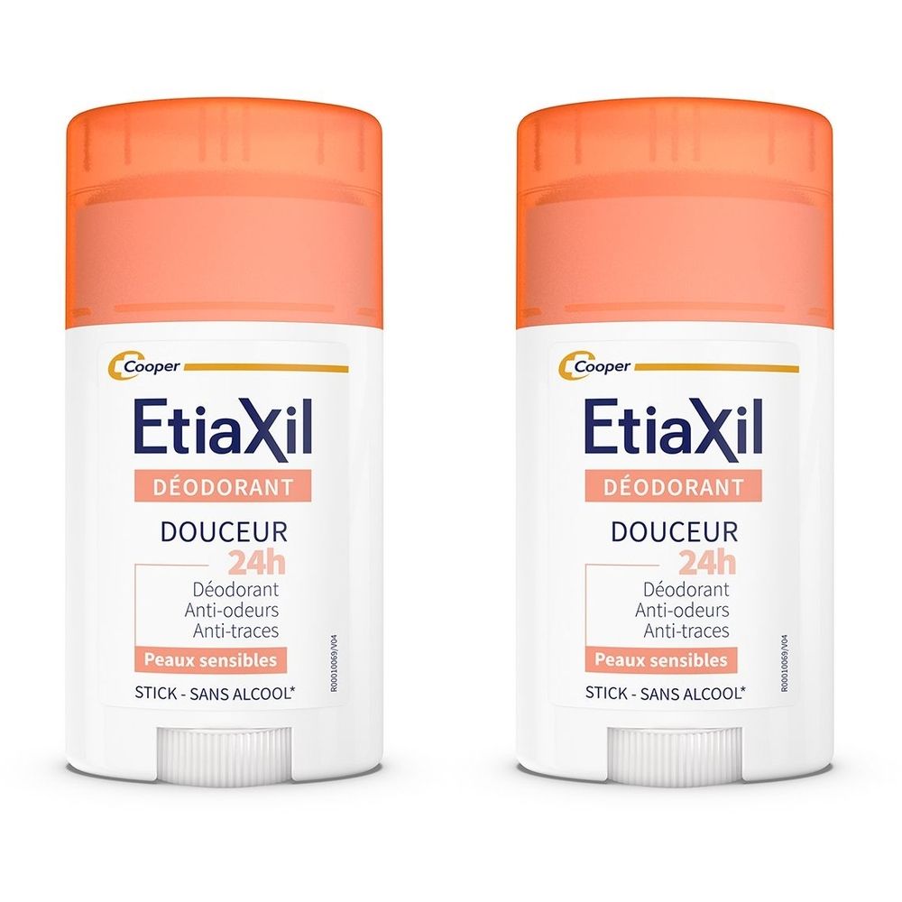 Zwei Deodorant-Sticks mit orangefarbenen Kappen. Aufschrift: Etiaxil, Déodorant, Douceur 24h, Anti-Geruch, Anti-Spuren, für empfindliche Haut, Stick, ohne Alkohol.