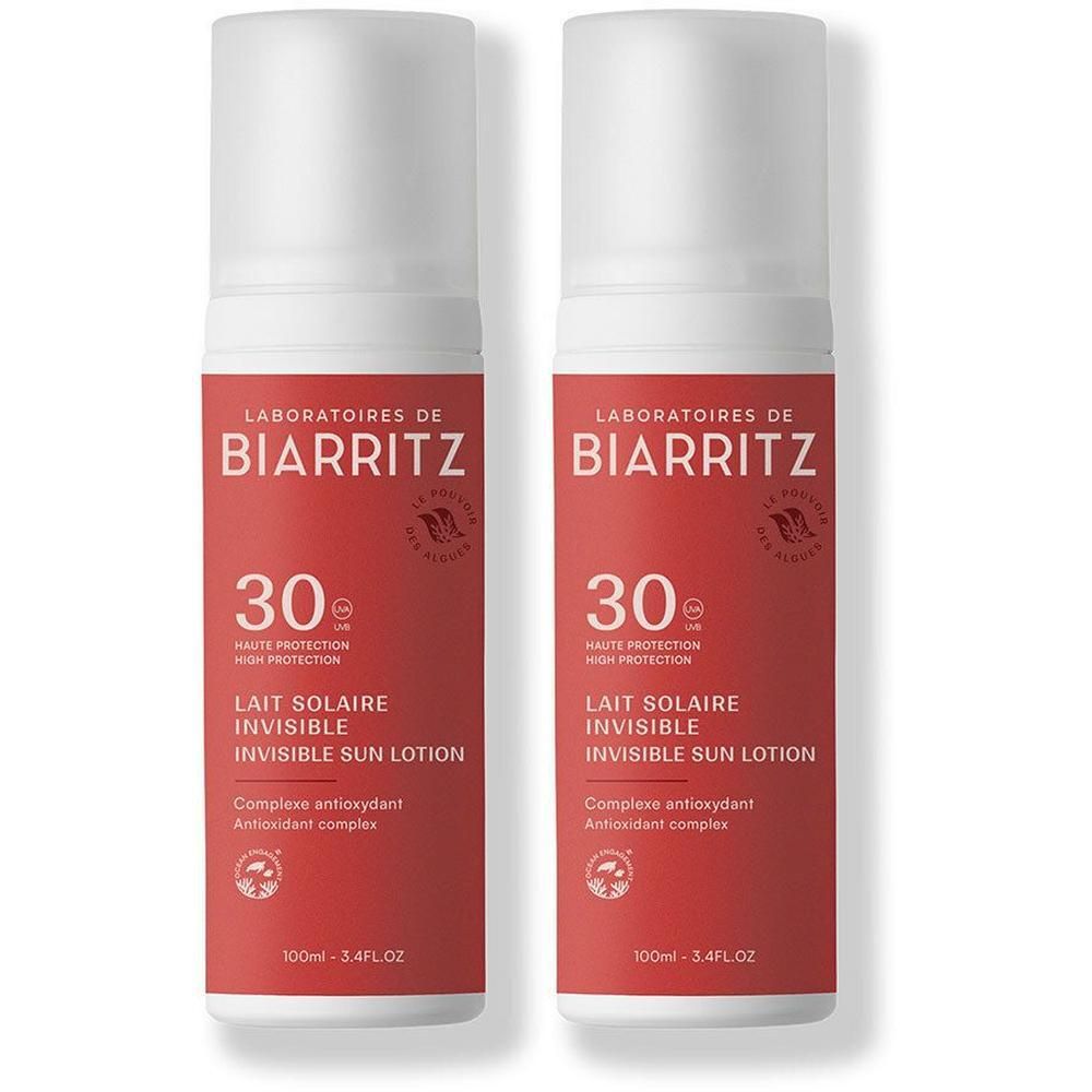 Deux flacons de lait solaire avec bouchon blanc et étiquette rouge. L'étiquette indique "LABORATOIRES DE BIARRITZ" et "30".