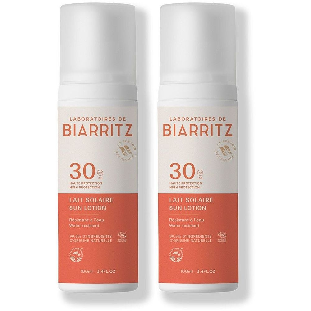 Deux flacons blancs de lait solaire. Inscription: Laboratoires de Biarritz, Lait Solaire, SPF 30. Résistant à l'eau.