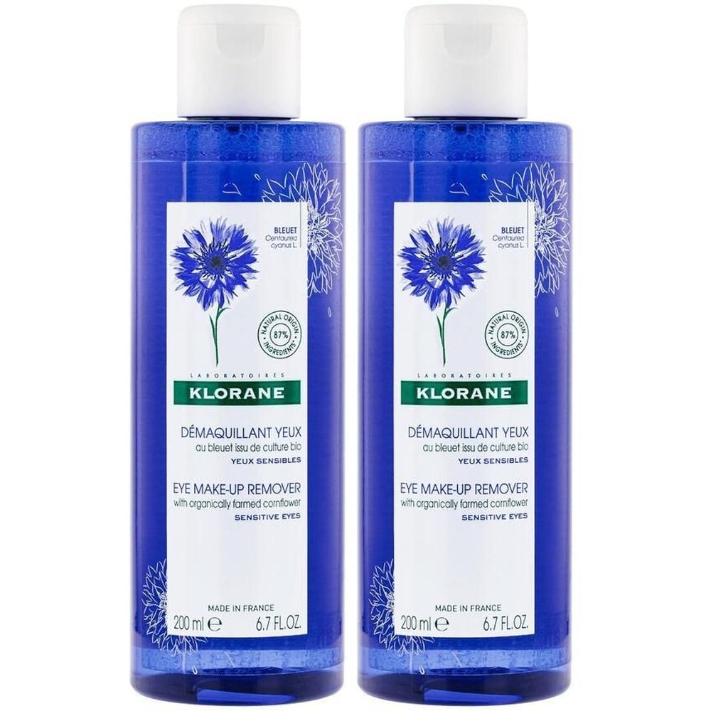 Deux flacons de démaquillant pour les yeux KLORANE. Bouteilles bleues avec bouchons blancs. Étiquette avec illustration de bleuet et nom du produit.