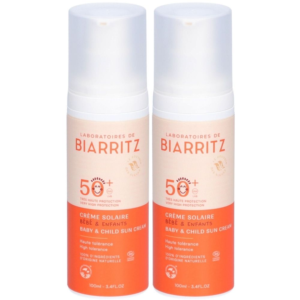 Deux crèmes solaires pour bébés et enfants. Flacons blancs avec étiquette orange. Inscription : LABORATOIRES DE BIARRITZ, SPF50+.
