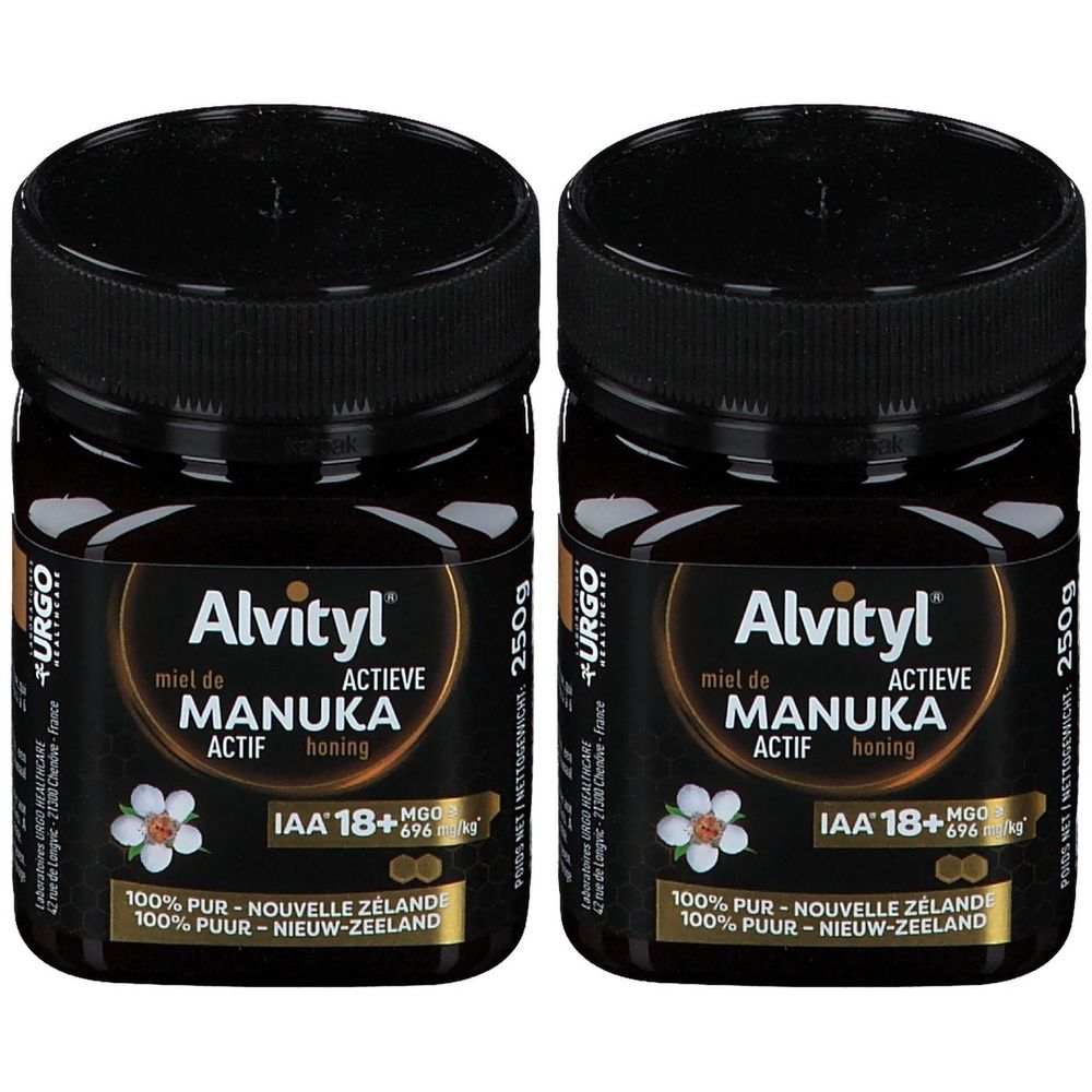 Zwei Gläser Alvityl Miel de Manuka ACTIF IAA 18+ Honig. Schwarze Gläser mit schwarzen Deckeln. Etikett mit Produktinformationen und Blüte.