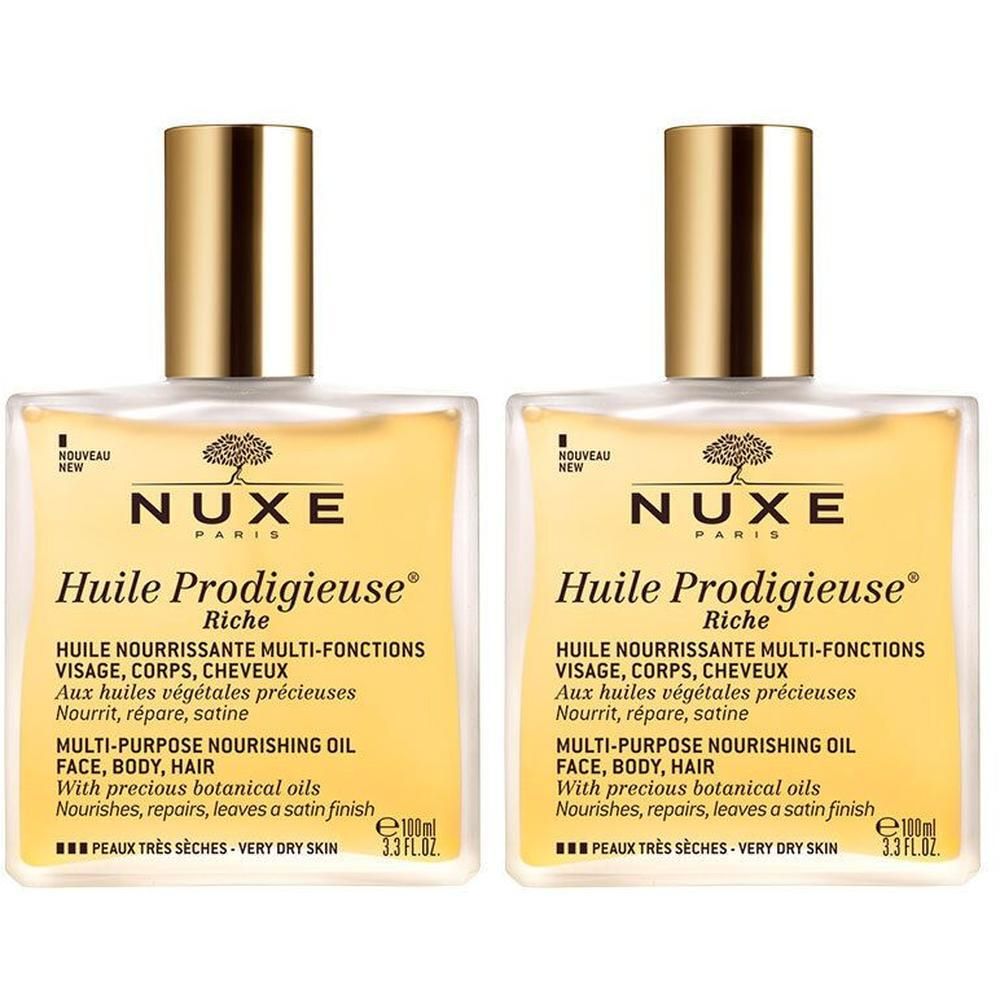 Deux flacons de NUXE Huile Prodigieuse® riche. Flacons carrés en verre avec bouchons dorés. Étiquette avec informations produit.