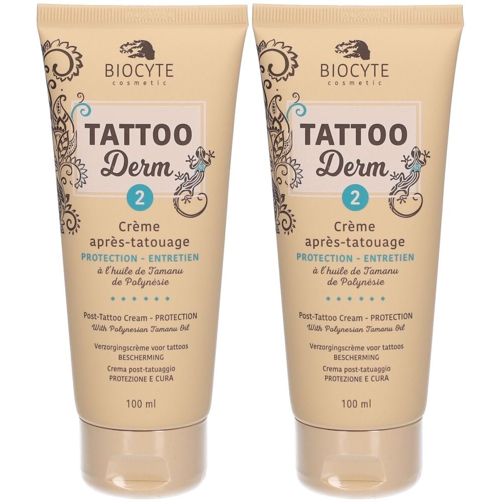 Zwei Tuben Creme für die Tattoo-Pflege. Beige Tuben mit Schriftzug "TATTOO Derm 2". Text in Französisch, Englisch, Niederländisch und Italienisch.