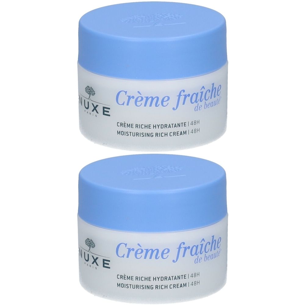 Deux pots de crème fraîche de beauté avec couvercles bleu clair. Inscription : Crème riche hydratante 48h, Nuxe.