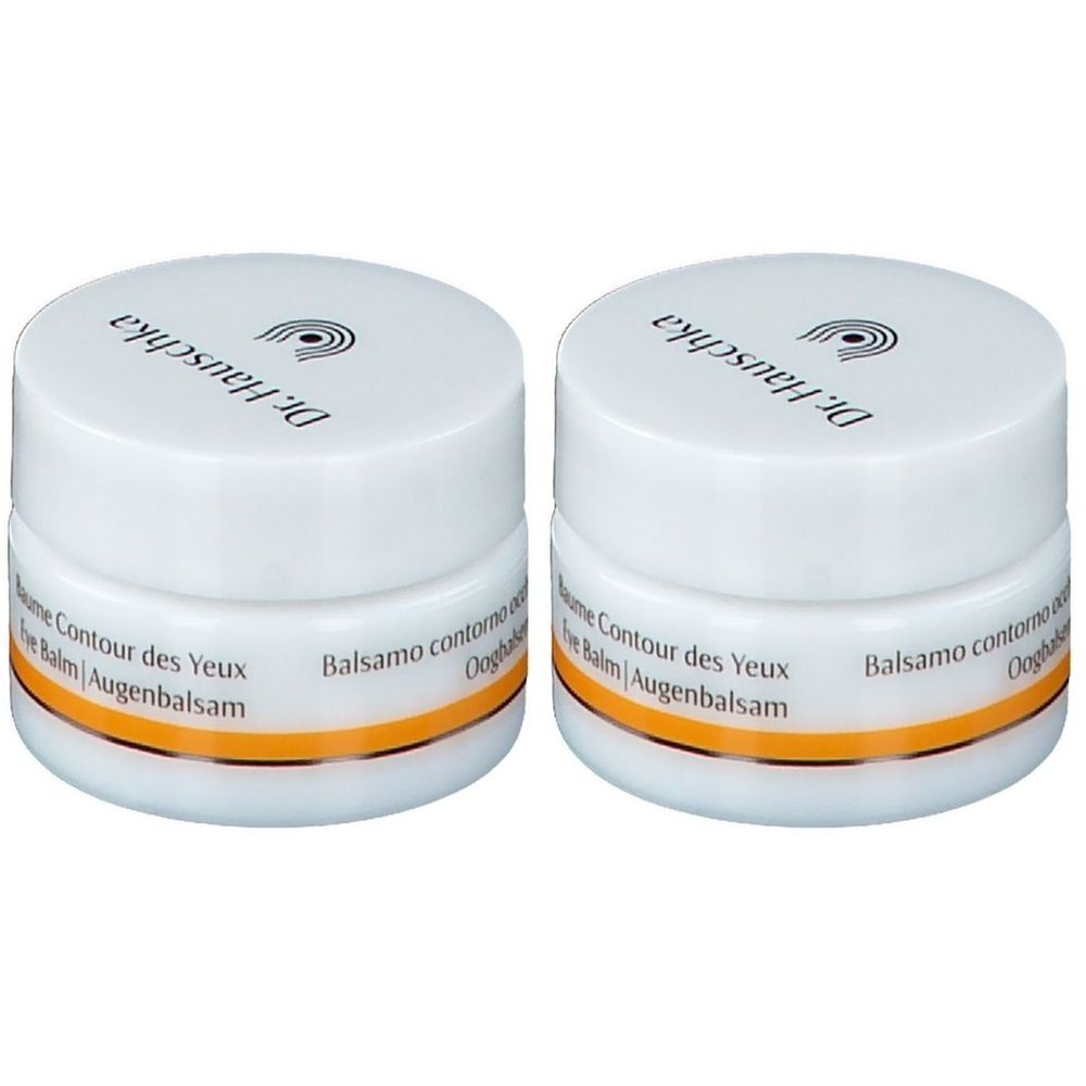 Zwei weiße Tiegel mit Deckel. Auf dem Deckel steht „Dr. Hauschka“. Unterhalb des Deckels ein goldfarbener Streifen. Aufschrift: „Baume Contour des Yeux Eye Balm Augenbalsam“.