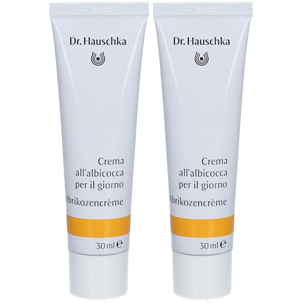 Deux tubes de crème sur fond blanc. Chaque tube porte la mention "Dr. Hauschka" et "Crema all'albicocca per il giorno".
