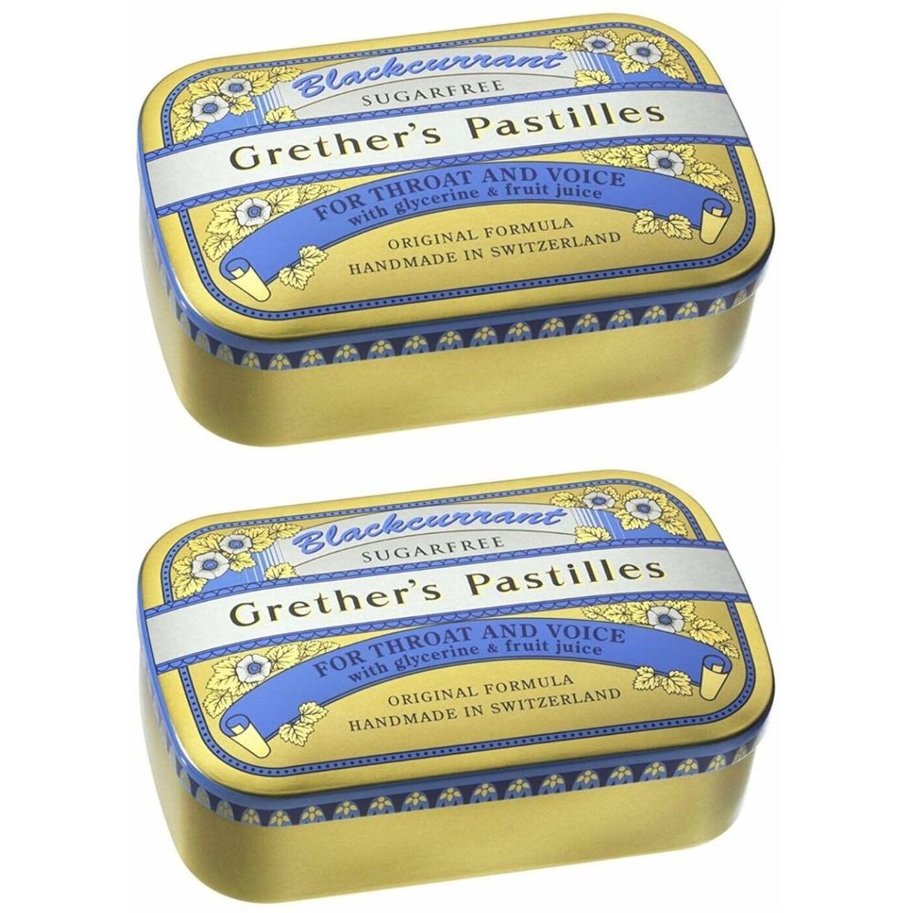 Zwei goldfarbene Pastillendosen mit blauer und weißer Beschriftung. Aufschrift: Grether's Pastilles, Blackcurrant, zuckerfrei.