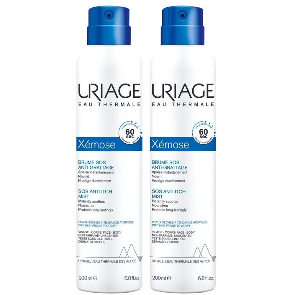 Zwei weiße Sprühflaschen mit blauen Deckeln. Aufschrift: URIAGE, Xémose, Brume SOS Anti-grattage. Text in Französisch und Englisch.