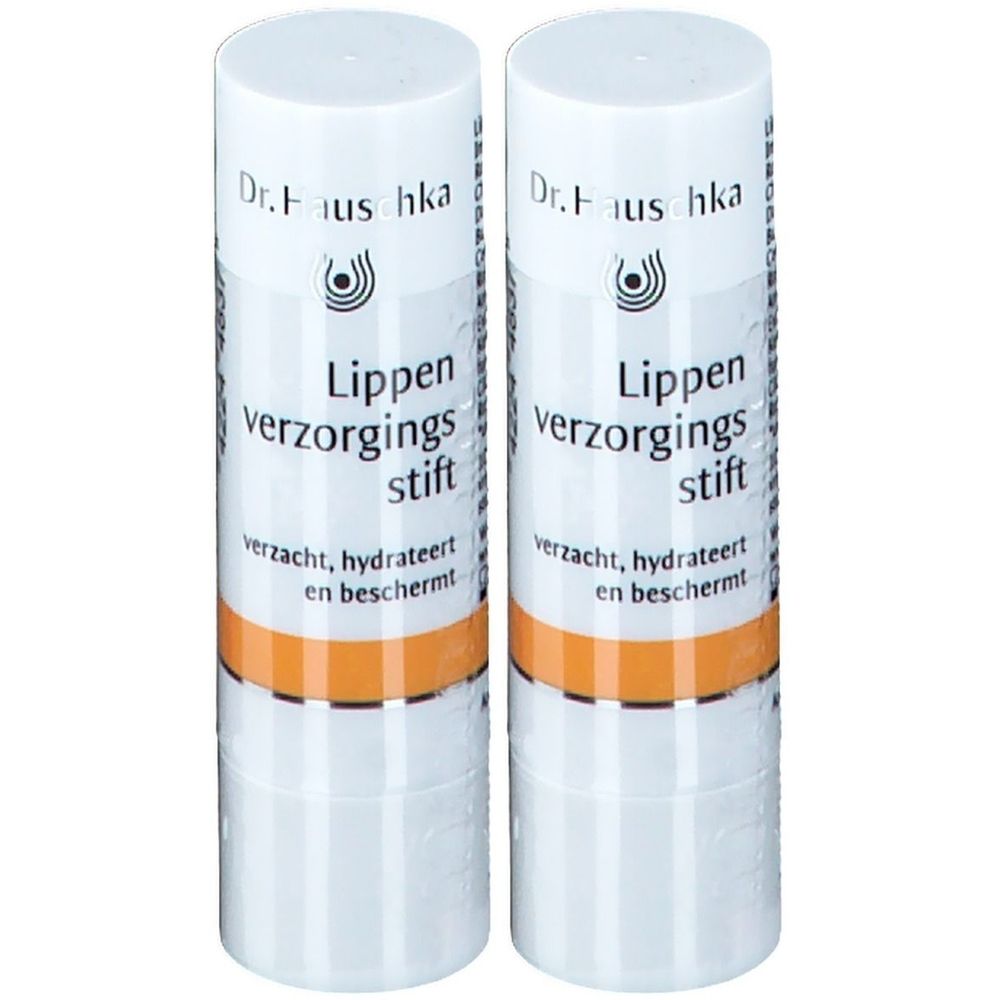 Zwei weiße Lippenpflegestifte mit orangefarbenem Band. Aufschrift: Dr. Hauschka, Lippen verzorgings stift.