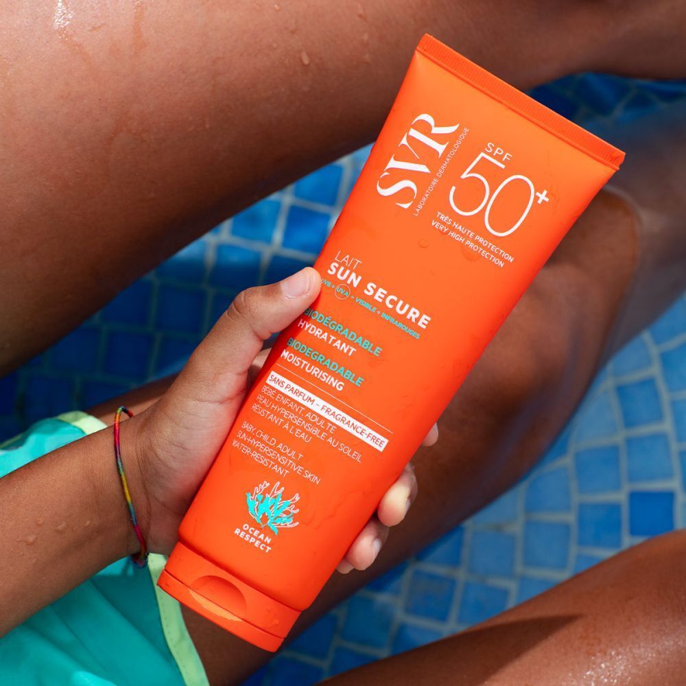 Tube orange de SVR Sun Secure Sonnenmilch SPF50+ tenue par une personne. Texte: Lait Sun Secure, SPF 50+, hydratant, fini invisible.