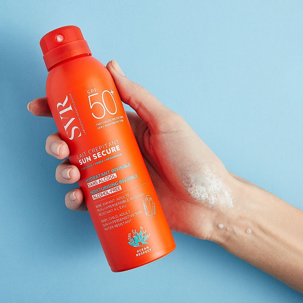 Une main tient un spray orange. Inscription: SVR, SPF 50+, SUN SECURE, hydratant invisible, sans alcool.