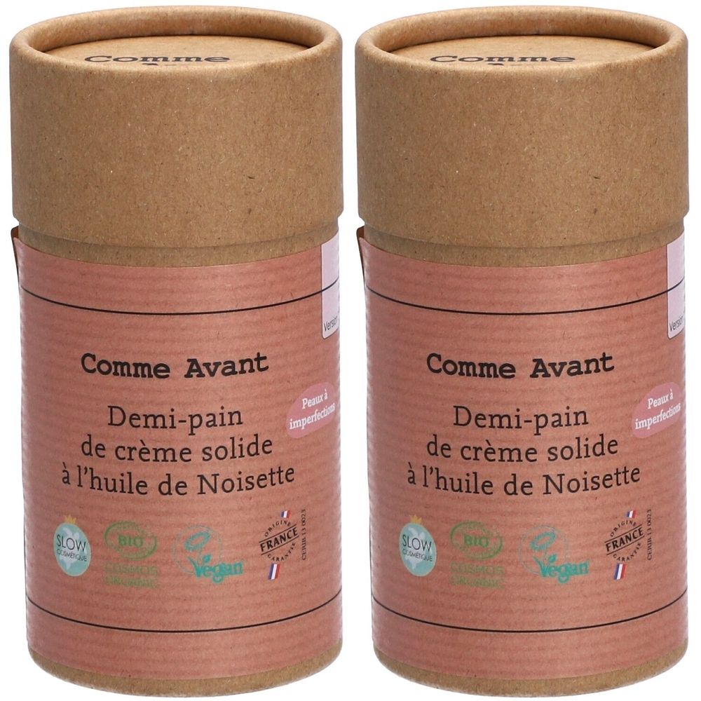 Zwei zylindrische Behälter. Aufschrift: Comme Avant, Demi-pain de crème solide à l'huile de Noisette. Mit Bio- und Vegan-Siegeln.