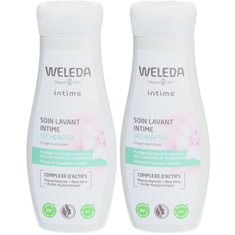 Deux flacons blancs avec bouchon blanc. Inscription: WELEDA intime, SOIN LAVANT INTIME SÉCHERESSE. Design floral et accents verts.