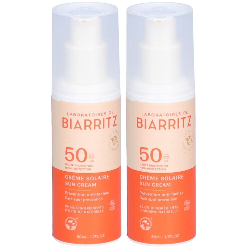 Deux flacons de crème solaire SPF 50. Inscription: LABORATOIRES DE BIARRITZ, Crème Solaire Sun Cream. Design orange et blanc.