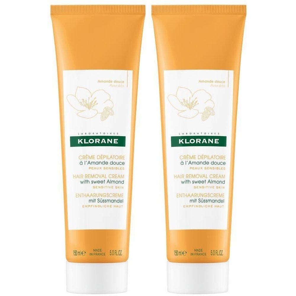 Zwei Tuben KLORANE Enthaarungscreme mit Süßmandel. Orangefarbene Tuben mit weißem Etikett und Produktinformationen.