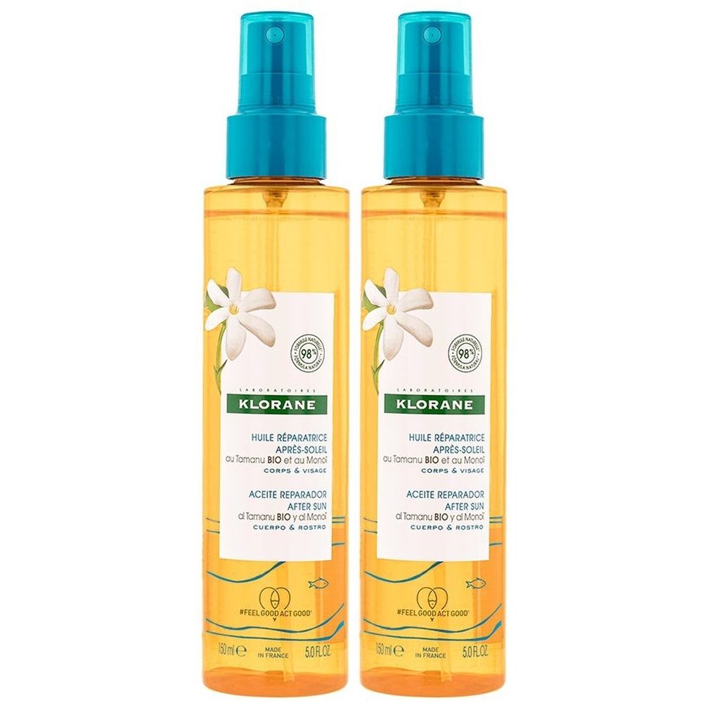 Zwei Sprühflaschen mit gelber Flüssigkeit. Blaue Sprühköpfe. Aufschrift: KLORANE, HUILE REPARATRICE APRES-SOLEIL. Mit weißen Blumen-Illustrationen.