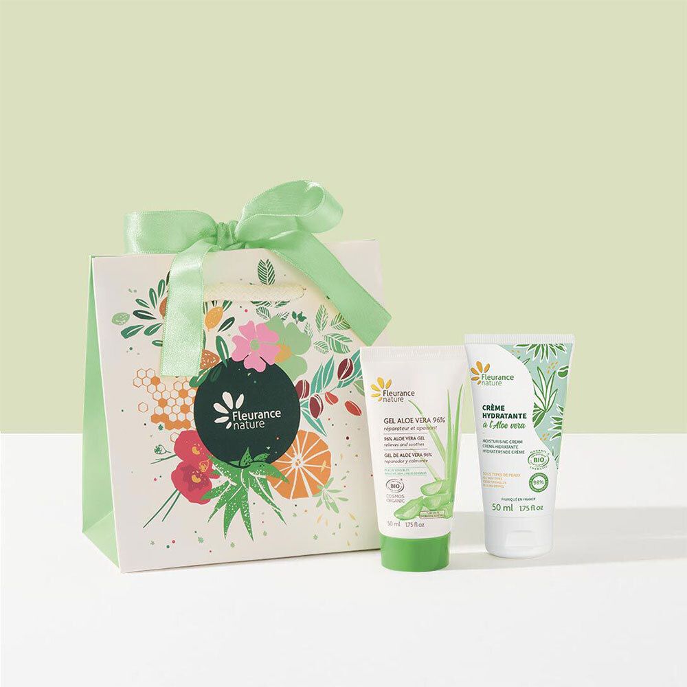Geschenkset mit zwei Tuben und einer Tüte mit Schleife. Eine Tube mit Aloe Vera Gel, die andere mit Creme. Auf der Tüte ist ein Logo und Blumenmuster.