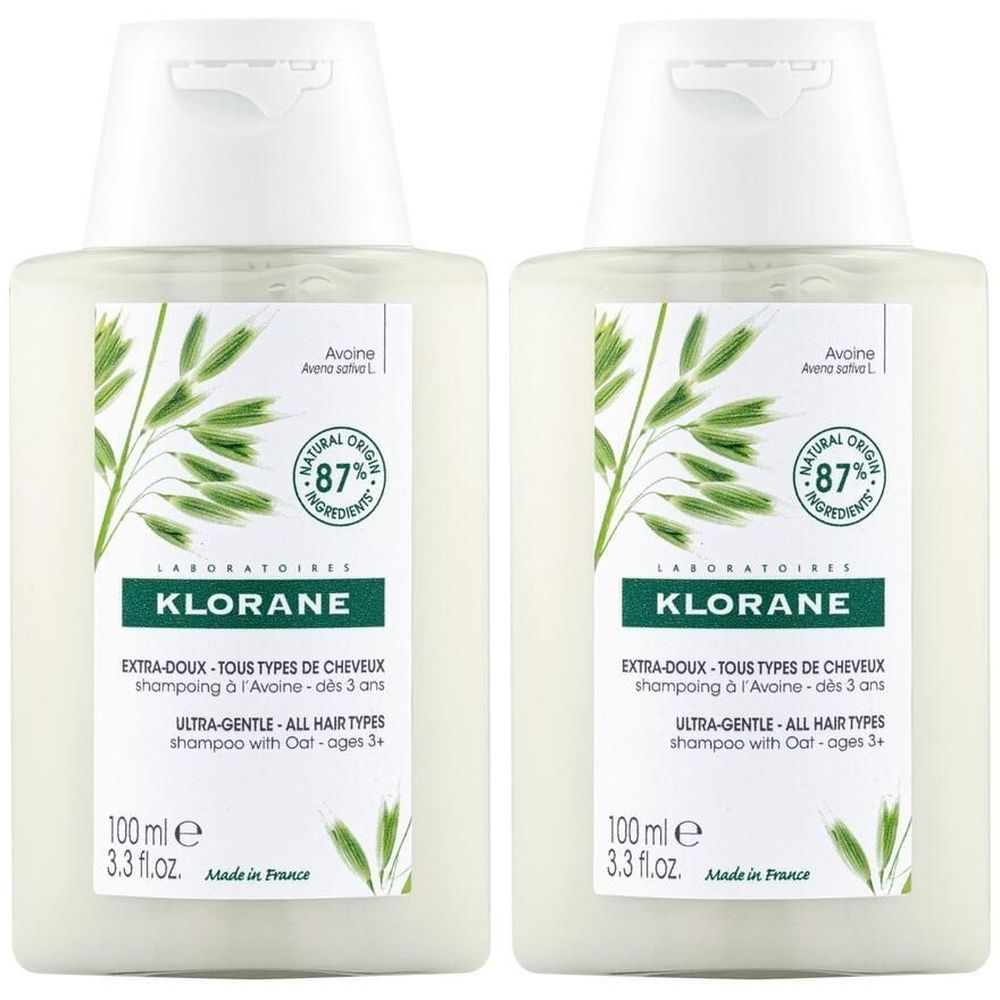 Zwei Flaschen KLORANE Shampoo Hafermilch. Weiße Flaschen mit grünem Etikett. Text: Extra-Doux, Tous Types de Cheveux, Ultra-Gentle, 87% Natural Origin.