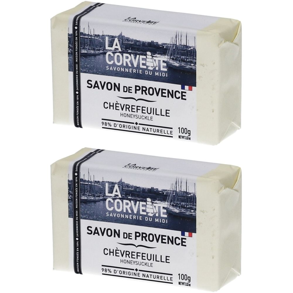 Zwei Seifenstücke mit Papierverpackung. Aufdruck: LA CORVETTE Savon de Provence Chèvrefeuille, 98% natürliche Herkunft, 100g.