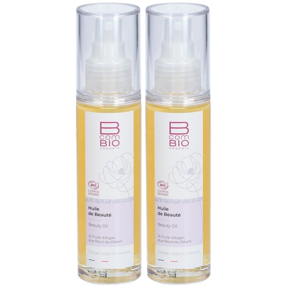 Zwei Flaschen Schönheitsöl. Klare Flaschen mit Sprühkopf. Etikett mit Logo, Produktname und Bio-Siegel. Gelbe Flüssigkeit sichtbar.