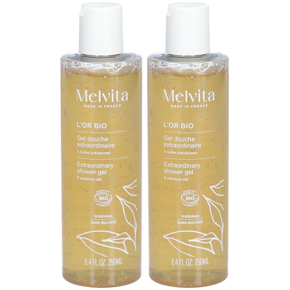Zwei Flaschen Duschgel. Transparentes Gel mit goldener Farbe. Aufschrift: Melvita, L'Or Bio, Extraordinary shower gel. Bio-Zertifizierung.
