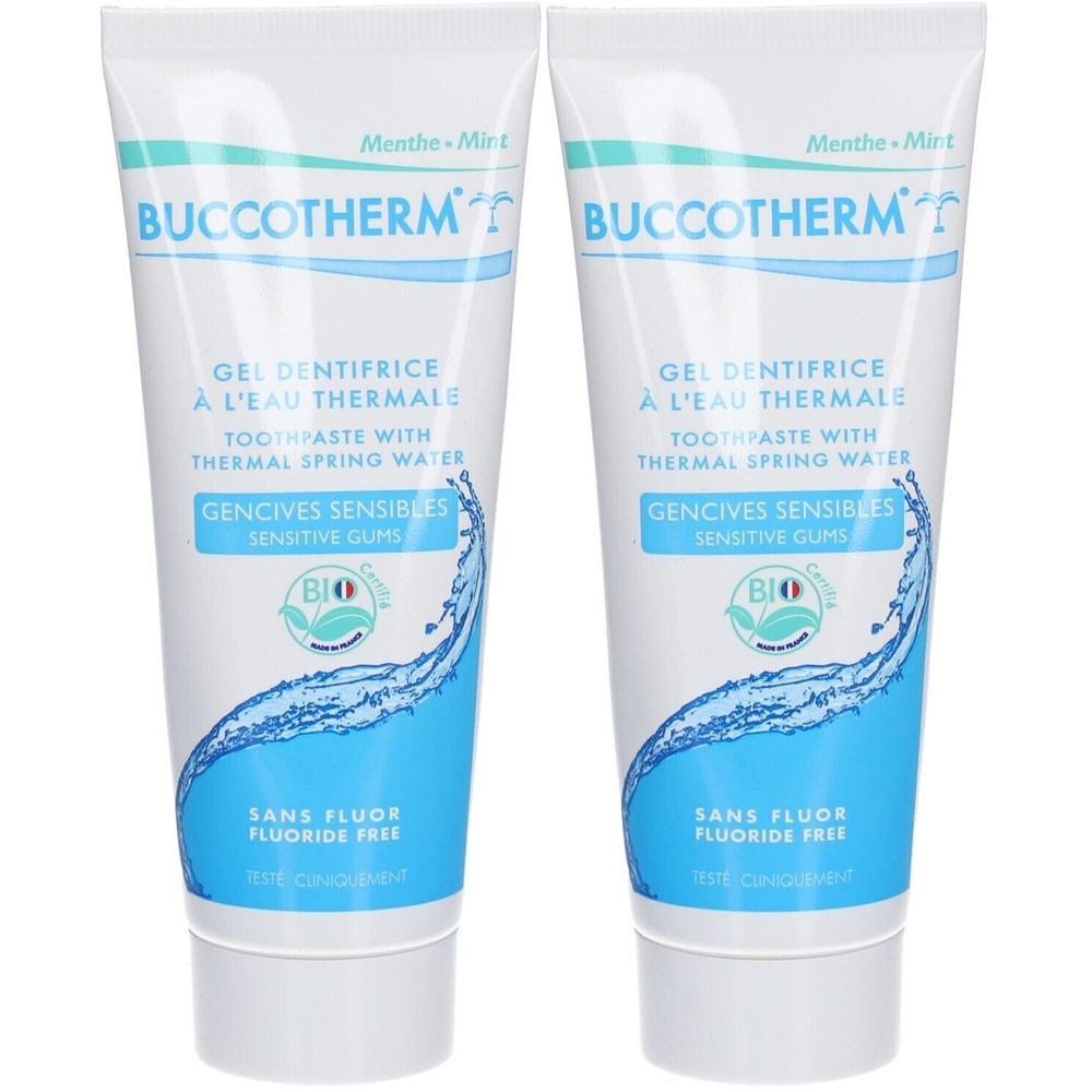 Deux tubes de gel dentifrice. Tubes blancs avec design bleu et texte. Inscription: Buccotherm, Gel Dentifrice, Gencives Sensibles, Sans Fluor.