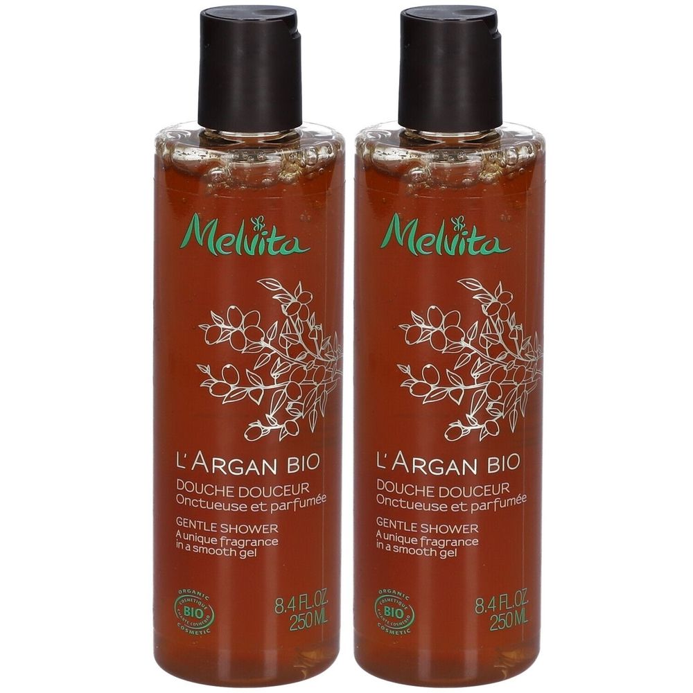 Deux flacons de gel douche. Liquide brun dans des bouteilles transparentes avec bouchon noir. Inscription : Melvita, L'Argan Bio, Douche Douceur.