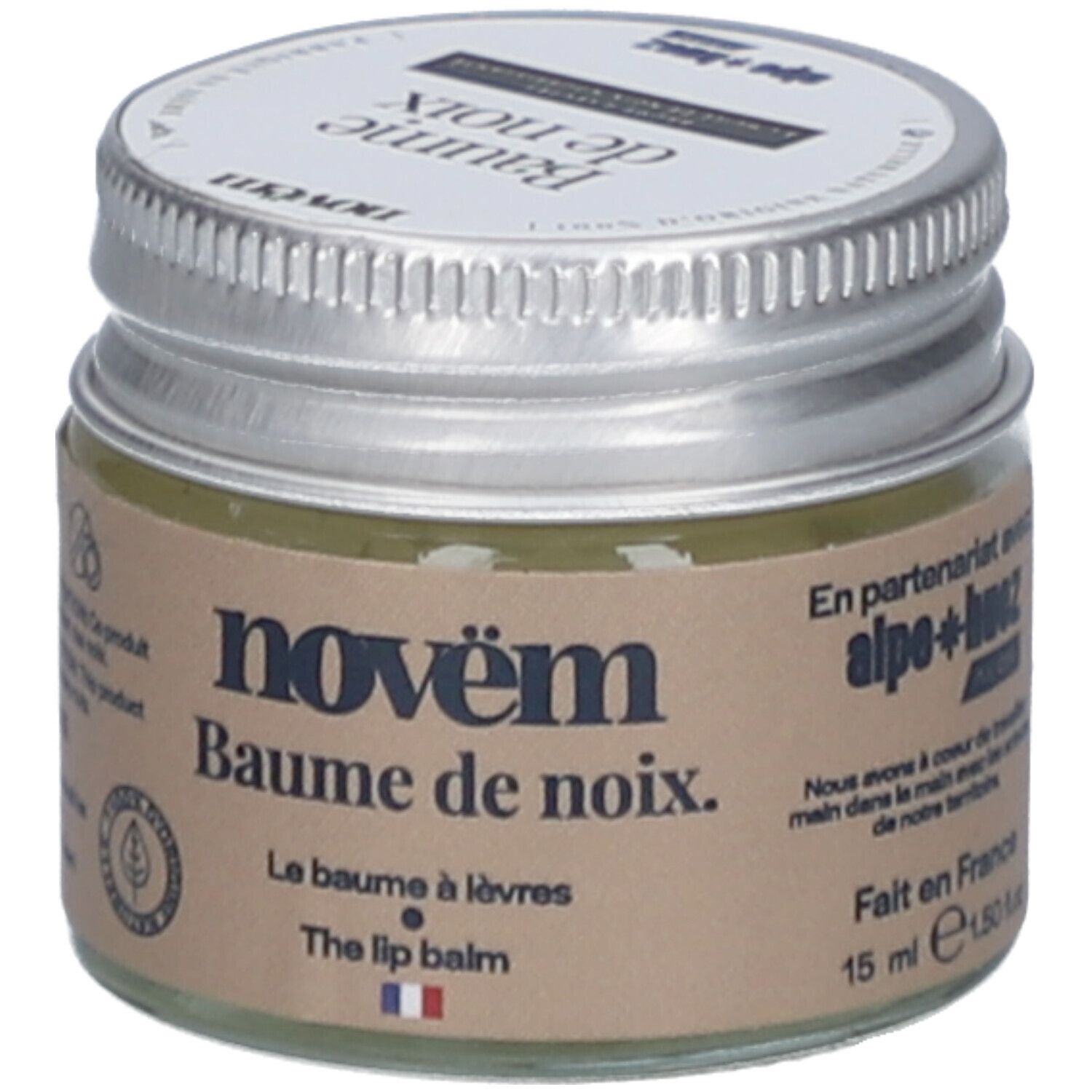 Glas mit silbernem Deckel. Aufkleber mit Produktnamen: novëm Baume de noix. Le Baume à lèvres. The lip balm. 15 ml. Hergestellt in Frankreich.