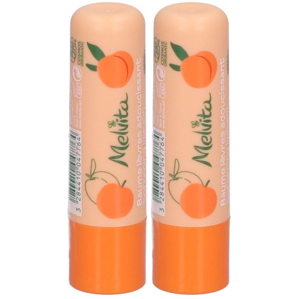 Zwei Melvita Lippenbalsame mit Pfirsich-Motiv und orangefarbenem Deckel.