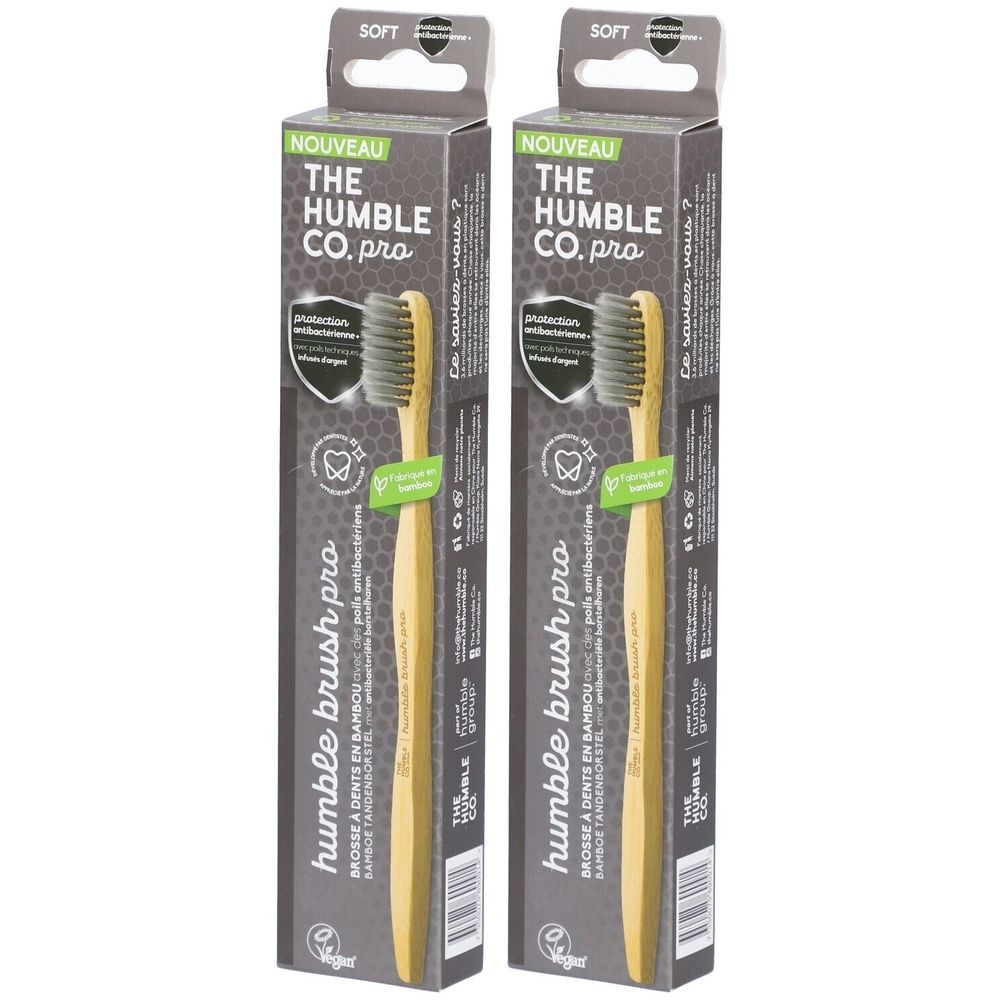 Zwei Zahnbürsten in Verpackung. Schwarze Borsten, Bambusgriff. Aufschrift: Humble Brush Pro. Verpackung mit Aufschrift: The Humble Co. pro.