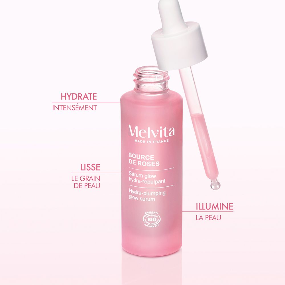 Rosa Flasche mit Pipette. Melvita Source de Roses Serum. Text und BIO-Logo.