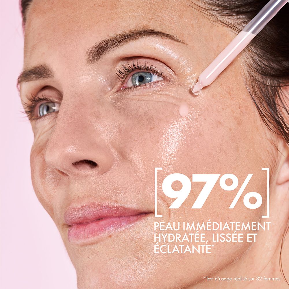 Frau mit Serum auf der Haut. Text: 97% sofort hydratisierte, glatte und strahlende Haut.