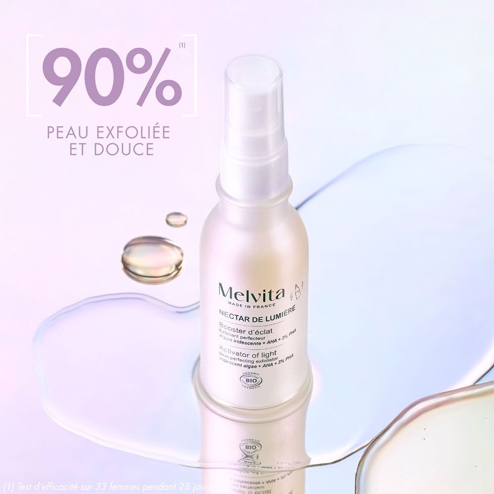 Flasche mit Zerstäuber auf spiegelnder Oberfläche. Text: 90% Peau exfoliée et douce. Melvita, Nectar de Lumière.