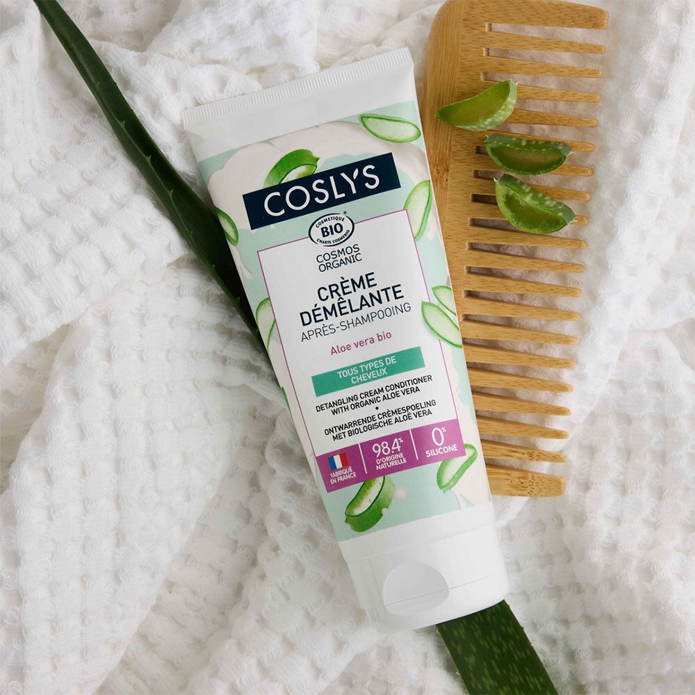 Creme-Tube mit Produktnamen und Logo, neben Kamm und Aloe-Blatt. Bio-Zertifizierung. Text: Crème démêlante, Aloe vera bio.