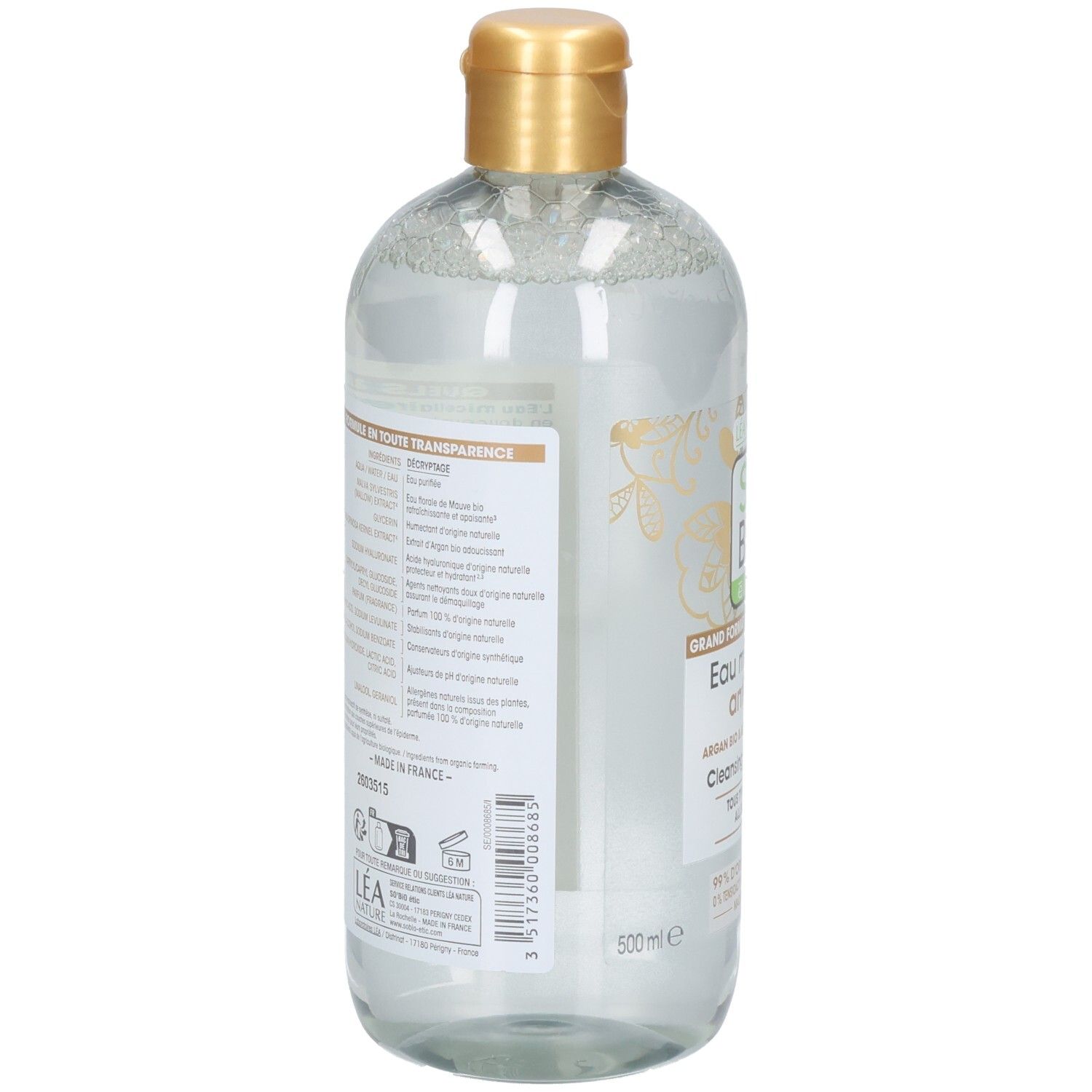 Rückansicht der Flasche. Etikett mit Text. Goldfarbener Verschluss. Transparente Flüssigkeit sichtbar.