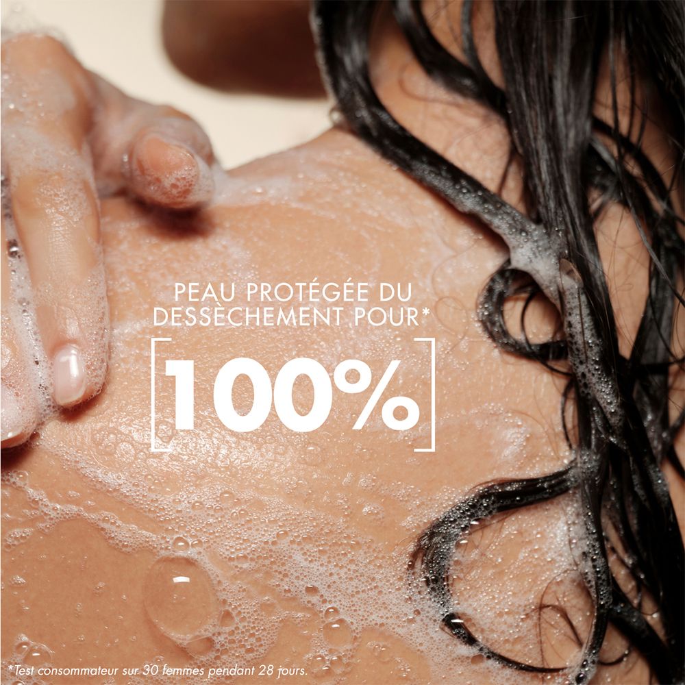 Nahaufnahme einer Schulter mit Schaum und Wassertropfen. Text: "PEAU PROTÉGÉE DU DÉSSÉCHEMENT POUR 100%".
