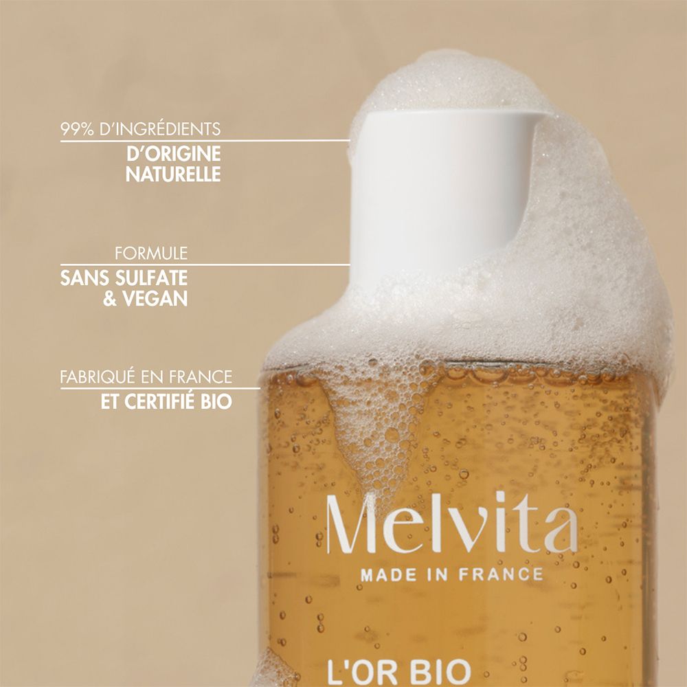 Nahaufnahme des Flaschenhalses eines Melvita Duschgels mit Schaum. Text: "99% D'INGRÉDIENTS D'ORIGINE NATURELLE", "FORMULE SANS SULFATE & VEGAN", "FABRIQUÉ EN FRANCE ET CERTIFIÉ BIO".