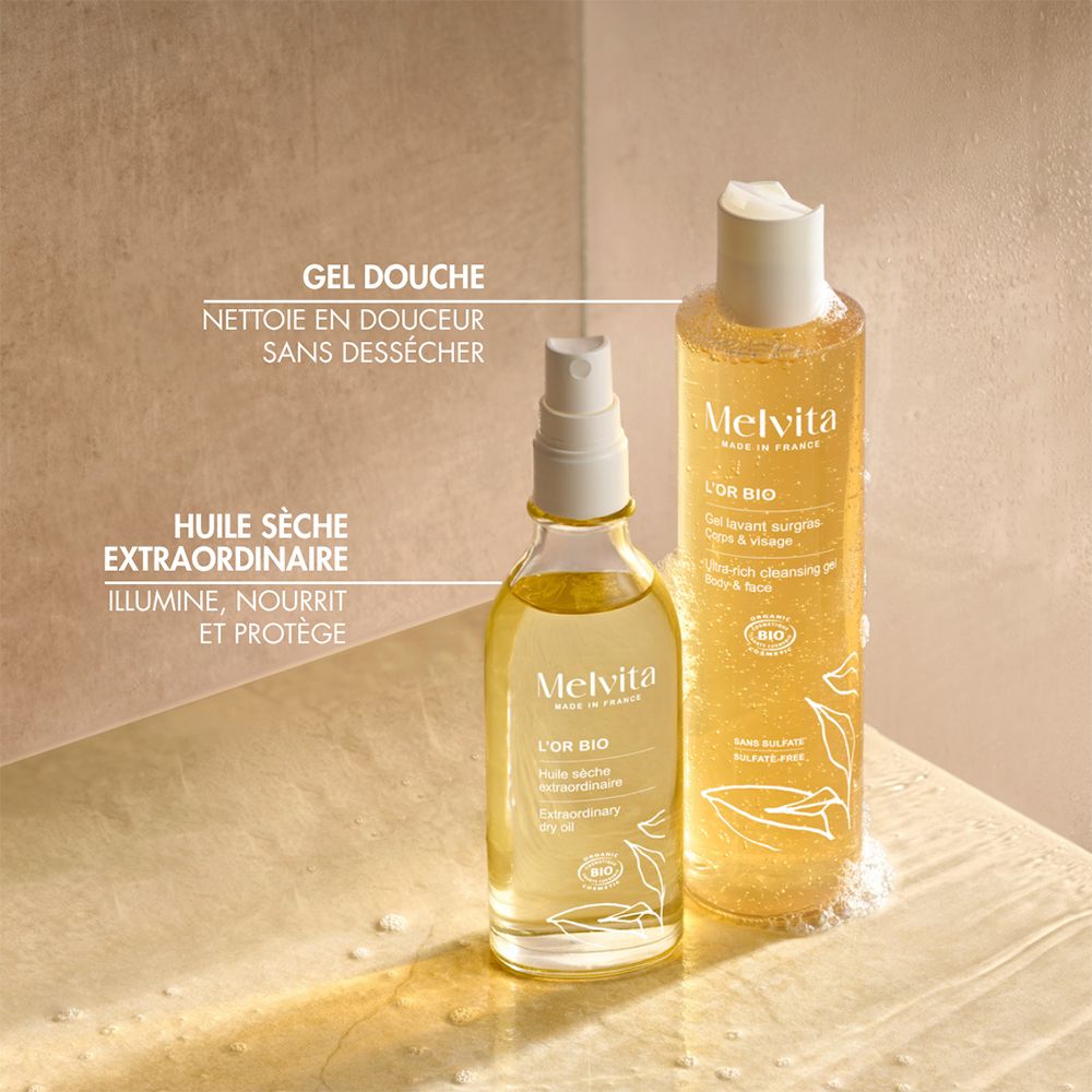 Zwei Melvita Produkte: Duschgel und Trockenöl. Text: "GEL DOUCHE NETTOIE EN DOUCEUR SANS DÉSSÉCHER" und "HUILE SÈCHE EXTRAORDINAIRE ILLUMINE, NOURRIT ET PROTÈGE".