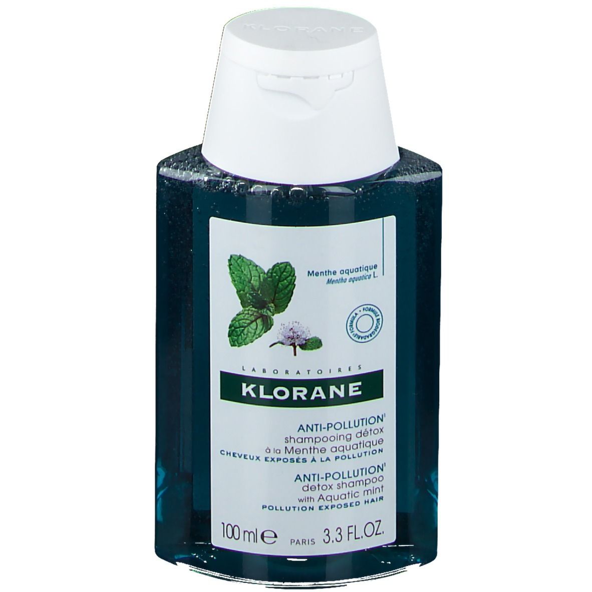 Flacon de shampooing Klorane, bouchon blanc. Étiquette avec illustration de menthe et texte.