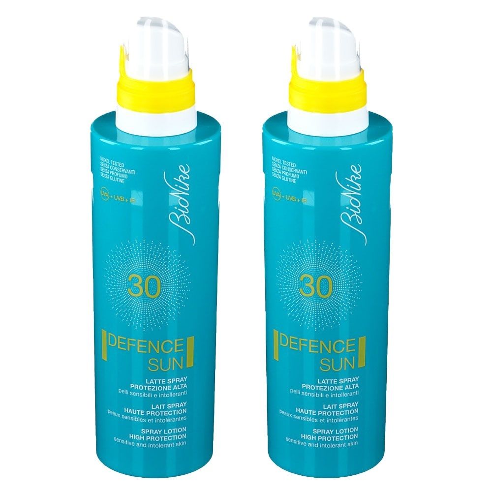 Deux flacons de spray bleus avec des accents jaunes. Inscription : BioNike, DEFENCE SUN LSF 30. Texte en italien, français et anglais.