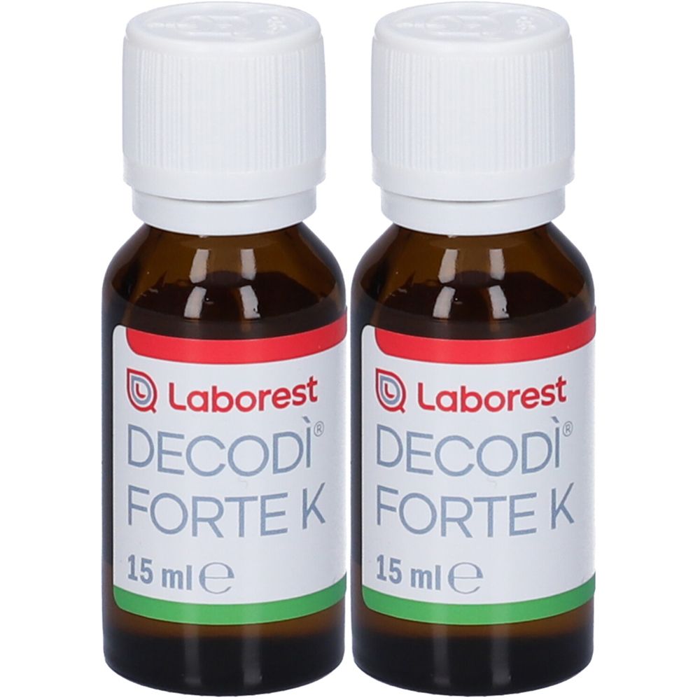 Deux flacons et emballages de Decodì® K forte. Flacons avec compte-gouttes et boîtes avec illustration de dinosaure solaire.
