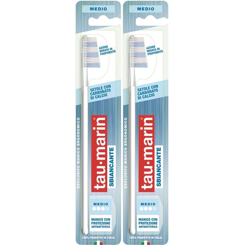 Deux brosses à dents emballées. Manche blanc, tête de brosse bleue. Marque : tau-marin, Sbiancante, Medio. Texte : Setole con Carbonato di Calcio.