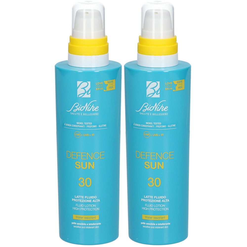 Zwei blaue Flaschen mit gelben Akzenten. Aufschrift: DEFENCE SUN 30, LATTE FLUIDO, PROTEZIONE ALTA. Marke: BioNike.