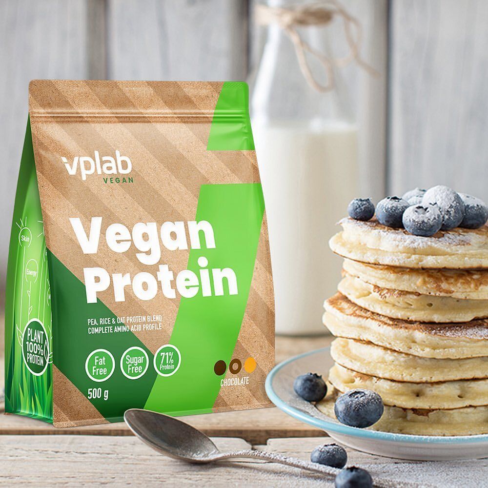 Vplab Vegan Protein Beutel neben Pfannkuchen mit Blaubeeren und Milch. Auf einem Holztisch.